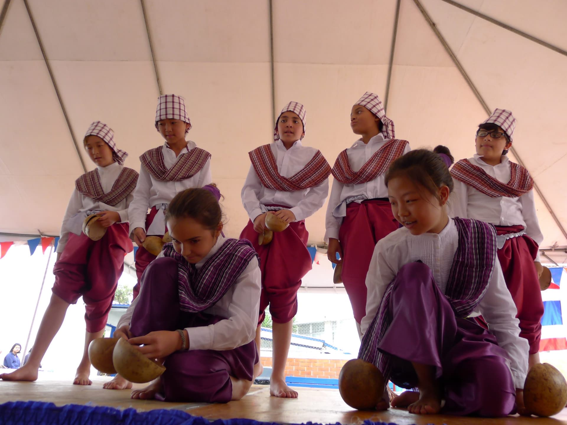 Elementary students in traditional dress performing with drums
